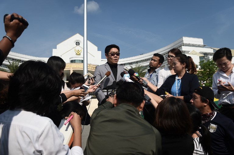 Kong Suriyamontol (C-with sunglasses), the Thai lawyer for Japanese national Mitsutoki Shigeta, speaks to the press after his client was granted paternity rights to his children, at a juvenile court in Bangkok on February 20, 2018. A Bangkok court on February 20 granted Shigeta "sole parent" rights to 13 babies fathered through Thai surrogate mothers, a ruling that paves the way for him to take custody of the children. / AFP PHOTO / LILLIAN SUWANRUMPHA