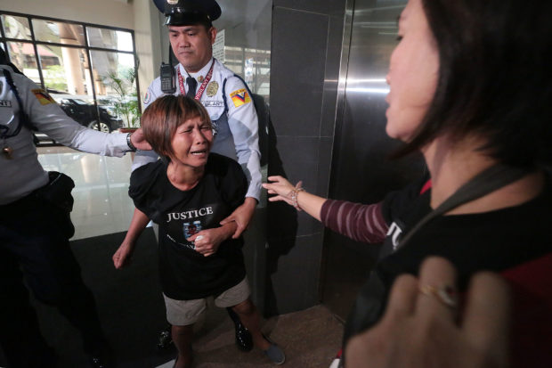 ANGUISH / FEBRUARY 5, 2018 Felicitas Sombrado, 53 years old, a parent whose child received the controversial Dengvaxia vaccine expresses frustration to former Health Secretary Janette Garin, who had just went up the elevator, as security guards restrain her at the lobby of Congress after the hearing on Dengvaxia on Monday, February 5, 2018. INQUIRER PHOTO / GRIG C. MONTEGRANDE