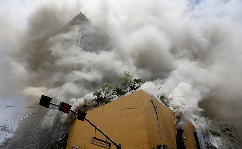 A fire engulfs the Manila Pavilion Hotel and Casino Sunday, March 18, 2018 in Manila, Philippines. The fire hit the hotel, where more than 300 guests were evacuated, some by helicopter, an official said. (AP Photo/Bullit Marquez)