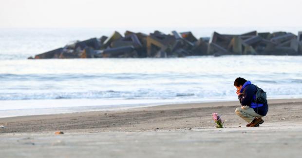 Man praying on Arahana coast in Japan - 11 March 2018