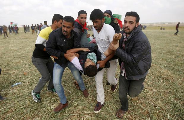 Palestinian protesters with wounded companion
