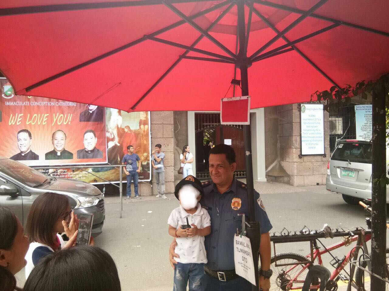 A child church-goer at the Immaculate Concepcion Cathedral in Pasig City takes photo with Pasig City Police Community Precinct 3 commander Sr. Insp. Gerardo Torres. Photo from Eastern Police District
