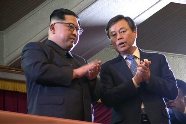 This picture captured from a video footage by Korea Pool reporters shows North Korean leader Kim Jong Un (L) and South Korea's Culture, Sports and Tourism Minister Do Jong-whan (R) during a rare concert by South Korean musicians at the 1,500-seat East Pyongyang Grand Theatre in Pyongyang on April 1, 2018. North Korean leader Kim Jong Un on April 1 attended the first concert in Pyongyang for over a decade by South Korean entertainers, including a K-pop girlband, the latest gesture of reconciliation before a rare inter-Korean summit. / AFP PHOTO / KOREA POOL / - / South Korea OUT