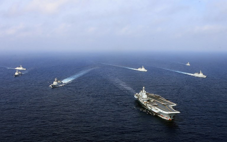 This undated photo taken in April 2018 shows China's sole operational aircraft carrier, the Liaoning (front), sailing with other ships during a drill at sea. A flotilla of Chinese naval vessels held a "live combat drill" in the East China Sea, state media reported early April 23, 2018, the latest show of force by Beijing's burgeoning navy in disputed waters that have riled neighbours. / AFP PHOTO / - / China OUT