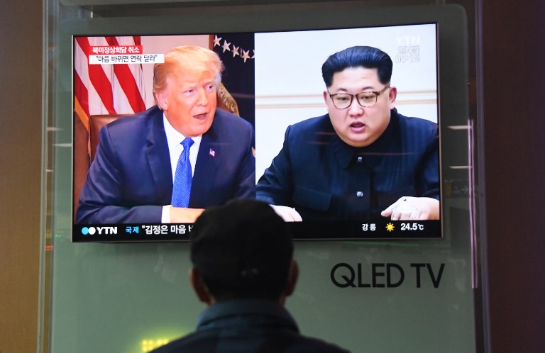 A man watches a television news screen showing US President Donald Trump (L) and North Korean leader Kim Jong Un (R), at a railway station in Seoul on May 25, 2018. US President Donald Trump on May 24 called off his planned June summit with Kim Jong Un, blaming "open hostility" from the North Korean regime and warning Pyongyang against committing any "foolish or reckless acts." / AFP PHOTO / Jung Yeon-je