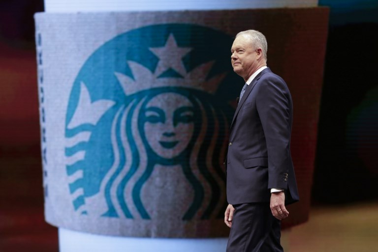 (FILES) In this file photo taken on March 21, 2018 Starbucks President and Chief Executive Officer Kevin Johnson walks on stage at the Starbucks Annual Meeting of Shareholders at McCaw Hall in Seattle, Washington on March 21, 2018.  Can you teach employees not to be racist? Coffee giant Starbucks will shut stores around the US on May 29, 2018, to conduct an unprecedented training exercise at its more than 8,000 US outlets. The initiative, which is expected to last four hours and reach 175,000 employees, was announced by Starbucks management on April 17, as it sought to contain outrage over the arrest of two young black men at one of its cafes in Philadelphia.  / AFP PHOTO / Jason Redmond / TO GO WITH AFP STORY by Catherine Triomphe, US-politics-racism-education-Starbucks