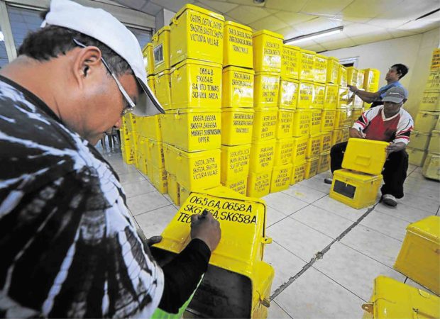 Photo of men preparing the ballot boxes for story:Comelec chief wants decision on barangay, SK polls before end of the month
