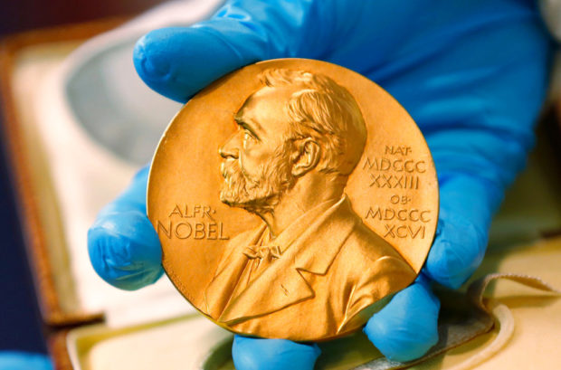 In this file photo dated Friday, April 17, 2015, a national library employee shows the gold Nobel Prize medal awarded to the late novelist Gabriel Garcia Marquez, in Bogota, Colombia. 