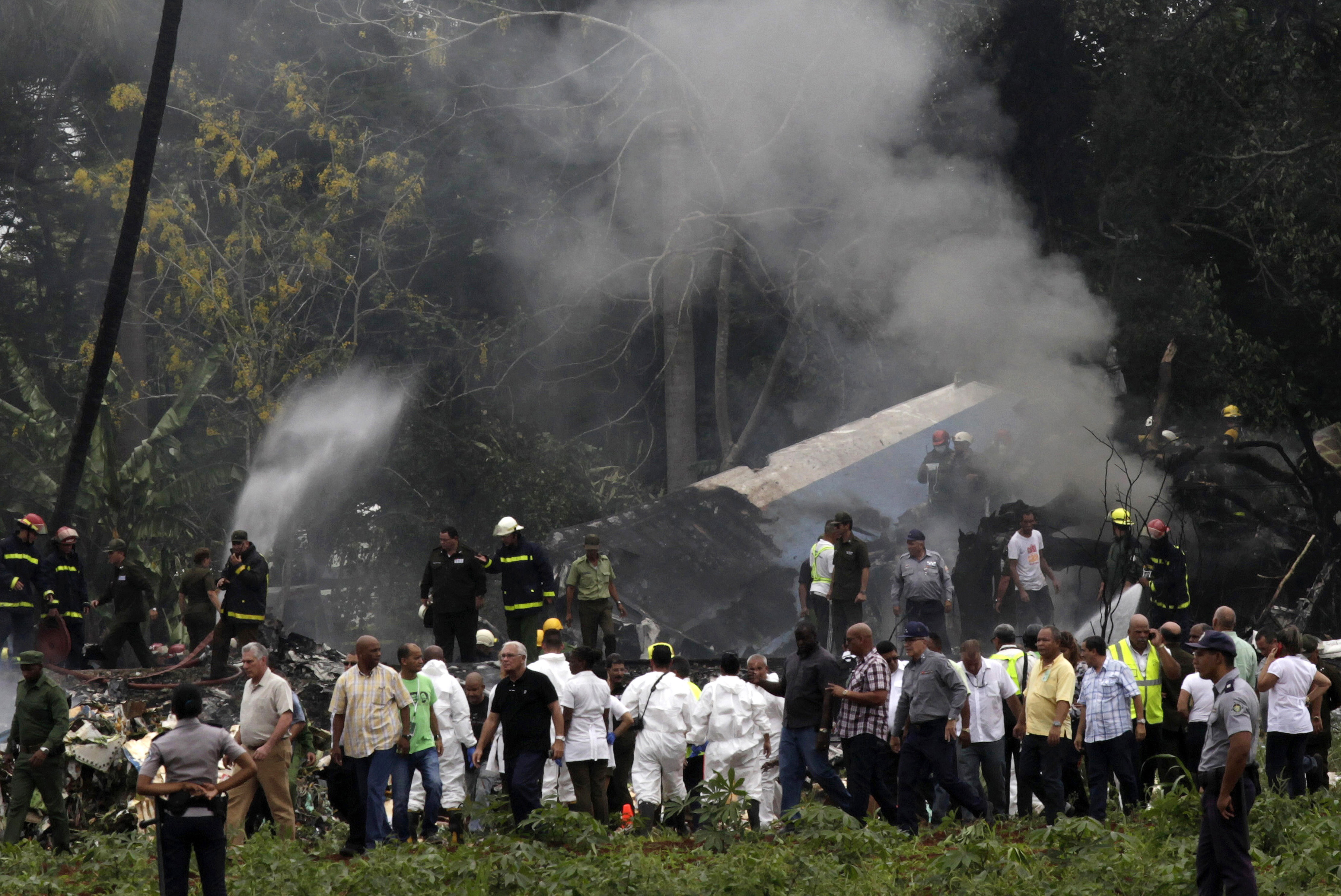Cuba's President Miguel Diaz-Canel, third from left, walks away from the site where a Boeing 737 plummeted into a yuca field with more than 100 passengers on board, in Havana, Cuba, Friday, May 18, 2018. The Cuban airliner crashed just after takeoff from Havana's international airport on Friday. (AP Photo/Enrique de la Osa) cuba