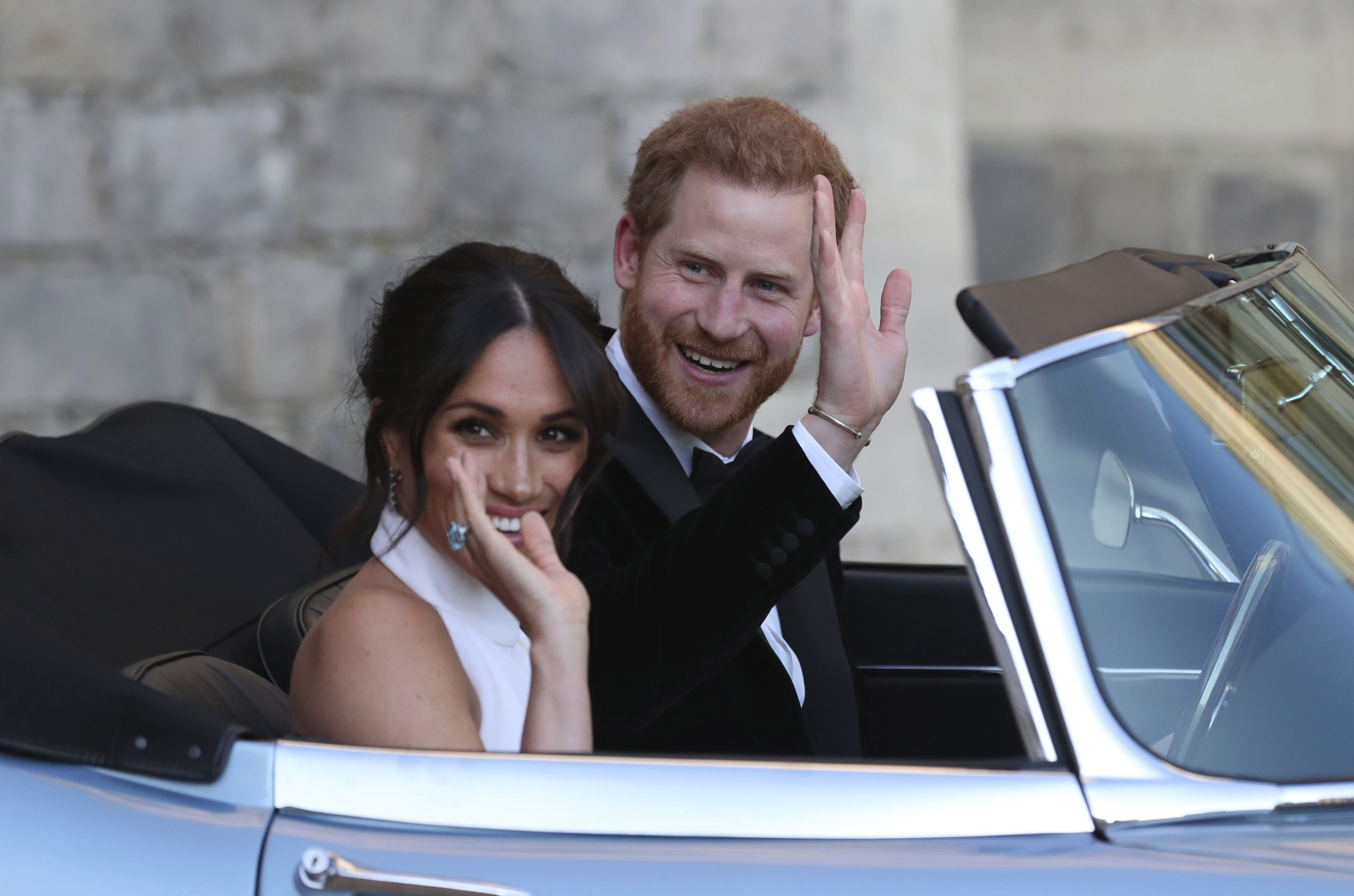 The newly married Duke and Duchess of Sussex, Meghan Markle and Prince Harry, leave Windsor Castle in a convertible car after their wedding in Windsor, England, to attend an evening reception at Frogmore House, hosted by the Prince of Wales, Saturday, May 19, 2018. (Steve Parsons/pool photo via AP)