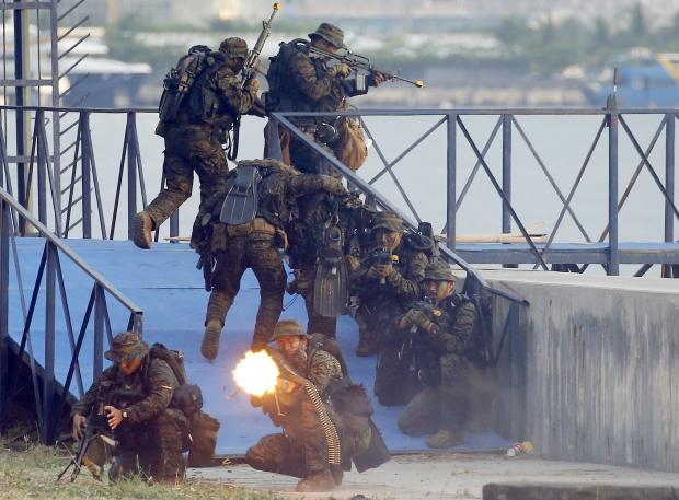 Navy SEALS on ground firing