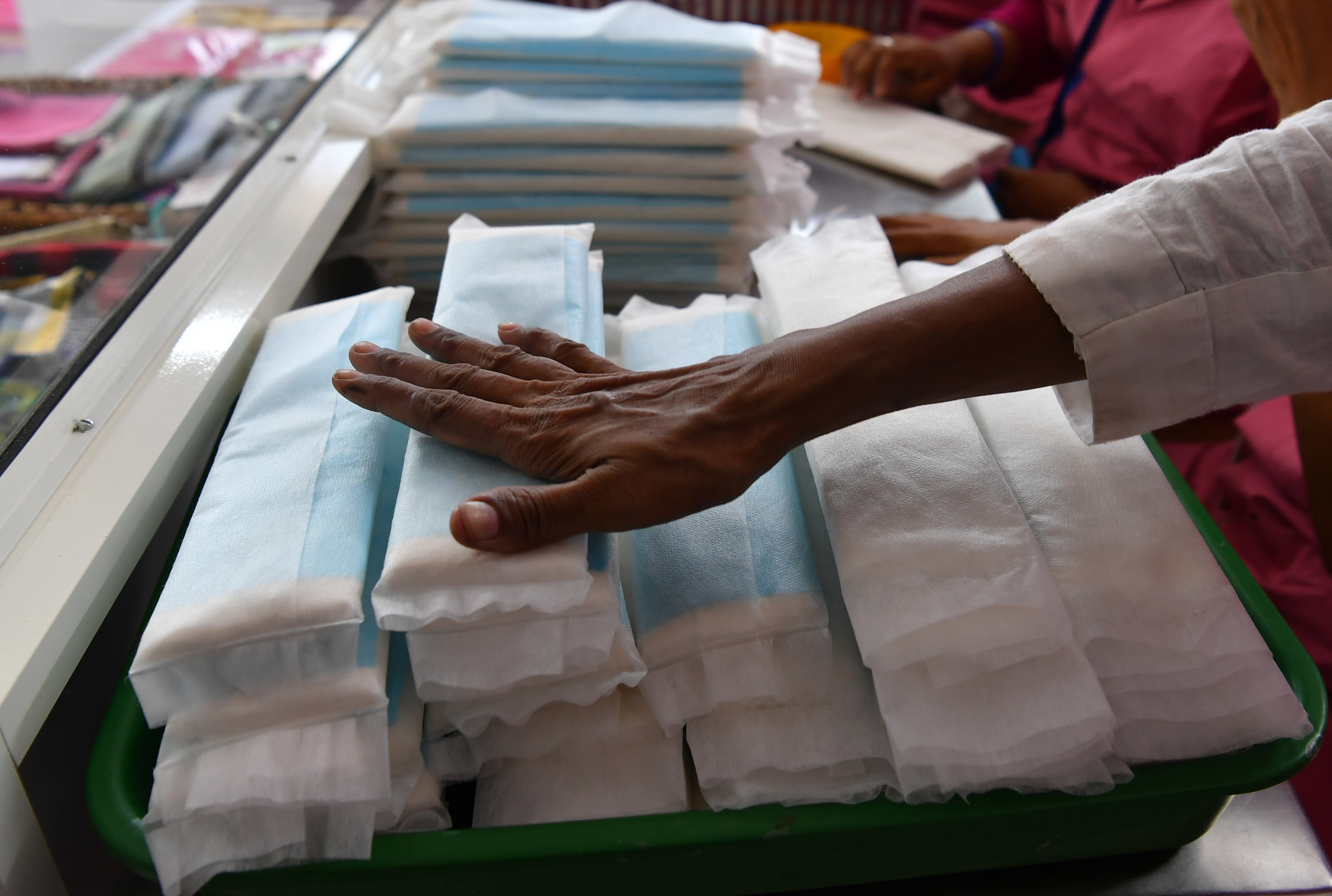 Отрезанный кусок ткани. Supermarket Sanitary Napkin display. Man showing Napkin.