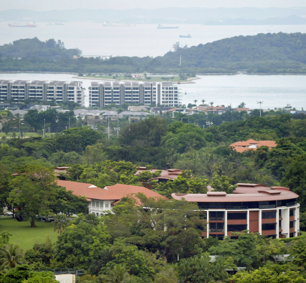 In this May 2018, photo, the Capella Hotel, foreground, sits in a green landscape on Sentosa Island in Singapore. U.S. President Donald Trump and North Korean leader Kim Jong Un will meet at the luxury resort for nuclear talks next week in Singapore, the White House said Tuesday, June 5, 2018. (Minoru Iwasaki/Kyodo News via AP)