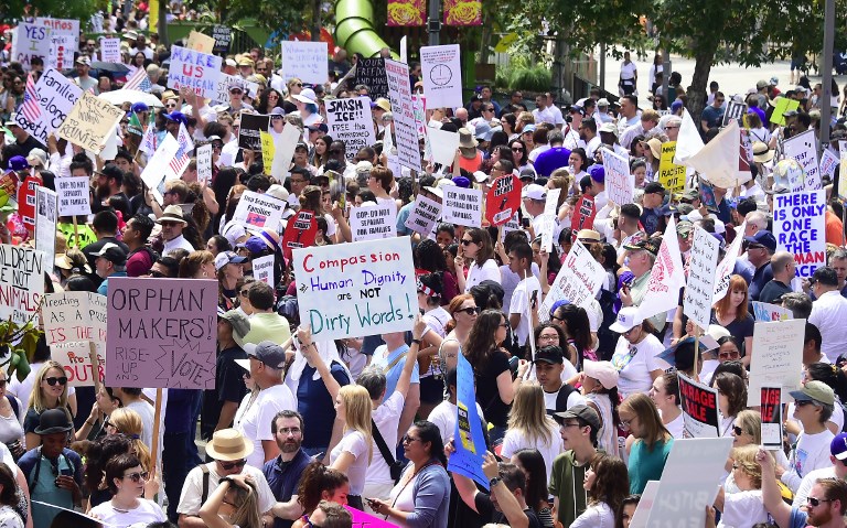 People hold placards during a 'Familes Belong Together' march and rally in Los Angeles, California on June 30, 2018 where a thousands turned out to decry the Trump administration's detention of families policy at the US Mexico border.  Thousands of demonstrators, baking in the heat and opposed to the US immigration policy, marched across the country Saturday, June 30, 2018 to protest the separation of families under President Donald Trump's hardline agenda.     / AFP PHOTO / Frederic J. BROWN