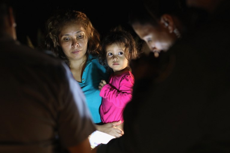 (FILES) This file photo taken on June 12, 2018 shows Central American asylum seekers, including a Honduran girl, 2, and her mother, near the US-Mexico border in McAllen, Texas. US officials have ordered DNA tests on "under 3,000" detained children who remain separated from their migrant parents, in an effort to reunite families at the center of a border crisis, a top US official said July 5, 2018. The Department of Health and Human Services is "doing DNA testing to confirm parentage quickly and accurately," HHS Secretary Alex Azar told reporters on a conference call, stressing the department was seeking to meet a court-imposed deadline of next Tuesday to reunite some 100 detained children under age five.  / AFP PHOTO / GETTY IMAGES NORTH AMERICA / John MOORE