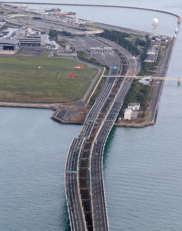 An aerial view from a Jiji Press helicopter shows damage caused by typhoon Jebi to a bridge leading to the Kansai International Airport in Izumisano, Osaka prefecture on September 5, 2018. The toll in the most powerful typhoon to hit Japan in a quarter century rose on September 5 to nine, with thousands stranded at a major airport because of storm damage. / AFP PHOTO / JIJI PRESS / JIJI PRESS / Japan OUT
