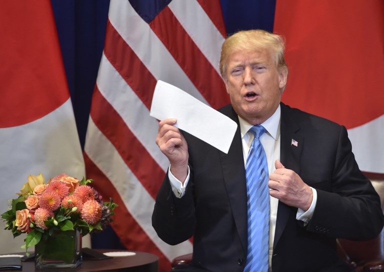 US President Donald Trump shows a letter he said he received the previous day from North Korean leader Kim Jong Un, during a bilateral meeting with Japanese Prime Minister Shinzo Abe (out of frame), September 26, 2018 on the sidelines of the United Nations General Assembly (UNGA) in New York. / AFP PHOTO / Nicholas Kamm