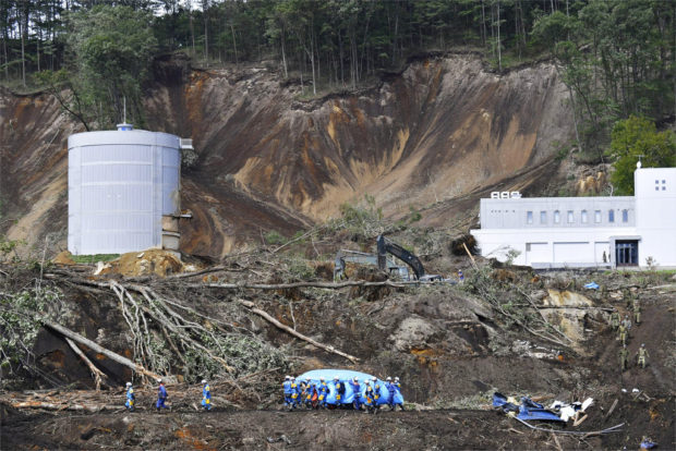 Rescuers carry the body of a victim at the site of a landslide triggered by Thursday's earthquake in Atsuma, Hokkaido, northern Japan Saturday, Sept. 8, 2018. Japanese rescue workers and troops searched Saturday for the missing for a third straight day in a northern hamlet buried by landslides from a powerful earthquake. Power was restored to most households and international flights resumed to the main airport serving the Hokkaido region. (Yohei Nishimura/Kyodo News via AP)