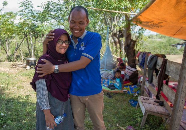 Indonesian This picture taken on October 1, 2018 shows Azwan hugging his wife Dewi Prasasti in front of their house and family members in Palu, Central Sulawesi, after an earthquake and tsunami hit the area on September 28. It was two agonising days of searches through makeshift morgues and hospitals before Azwan found his wife Dewi alive and well after she was swept away in the tsunami that crashed into the Indonesian city of Palu. / AFP PHOTO / Bay ISMOYO / TO GO WITH Indonesia-quake-tsunami, FOCUS by Harry PEARL