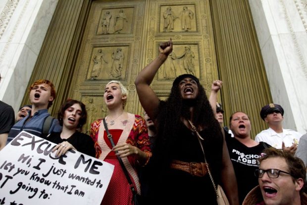 Demonstrators block the main entrance door as they take the steps of the US Supreme Court to protest against the appointment of Supreme Court nominee Brett Kavanaugh in Washington DC, on October 6, 2018. / AFP PHOTO / Jose Luis Magana