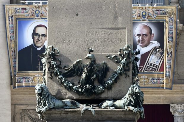 The tapestries of Roman Catholic Archbishop Oscar Romero (L) and Pope Paul VI hang from a balcony of the facade of St Peter's Basilica at the Vatican on October 13, 2018. - Pope Francis will preside on October 14, 2018 over canonisation mass for pope Paul VI and slain Salvadorean archbishop Oscar Romero. (Photo by Filippo MONTEFORTE / AFP)