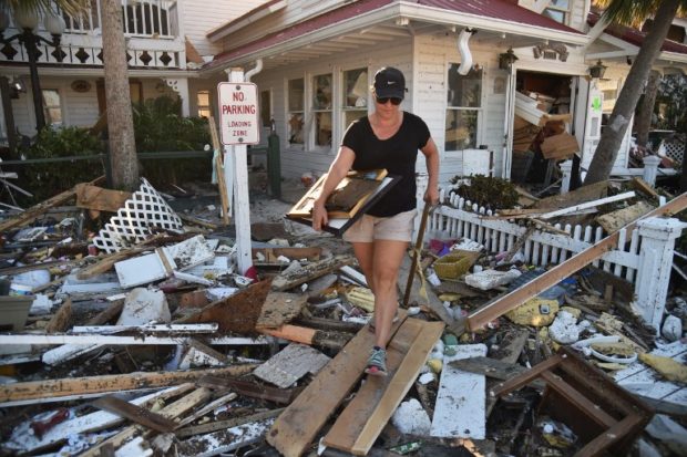 EDITORS NOTE: Graphic content / Brandy Jessen helps recovering belongings from her mother's house damaged by Hurricane Michael, in Mexico Beach, Florida, on October 13, 2018, three days after Hurricane Michael hit the area. - Since Hurricane Michael roared through on October 10, a wide swath of Florida's northwest coast has been without telephone or Internet service, adding to the daunting challenges facing residents, loved ones trying to reach them, and the work crews struggling to bring them relief. A bridge was washed out between Mexico Beach and Port St. Joe to the southeast, making it impossible to get there via coastal roads (Photo by HECTOR RETAMAL / AFP)