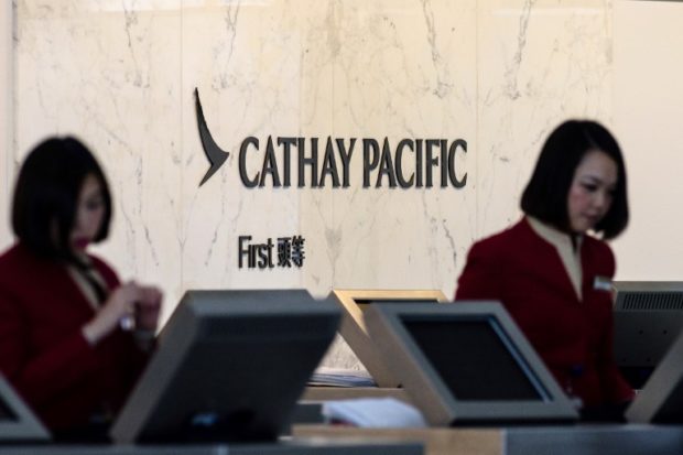 (FILES) In this file photo taken on March 15, 2017, Cathay Pacific employees work at their counters at the international airport in Hong Kong. - Shares in Hong Kong carrier Cathay Pacific plunged 6.5 percent on the morning of October 25, 2018 after it admitted to suffering a major data leak affecting up to 9.4 million passengers. (Photo by Anthony WALLACE / AFP)