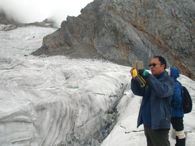 This Sept. 22, 2018 photo shows glaciologist Wang Shijin photographing the Baishui Glacier No.1 on the Jade Dragon Snow Mountain in the southern province of Yunnan in China. Scientists say the glacier is one of the fastest melting glaciers in the world due to climate change and its relative proximity to the Equator. It has lost 60 percent of its mass and shrunk 250 meters since 1982. (AP Photo/Sam McNeil) china