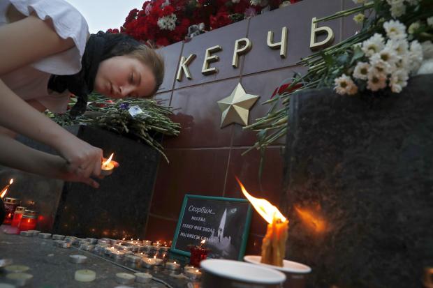 Girl lights candle for victims of Crimea school shooting