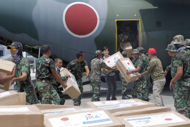 Indonesian and Japanese troops unloading relief good for quake survivors