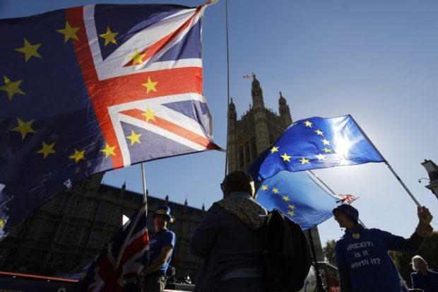 (FILES) In this file photo taken on October 9, 2018 Anti-Brexit campaigner Steve Bray (L) and other activists stand outside parliament with EU and Union Flags as they protest in Parliament Square in London. - British and Irish ministers said November 2, 2018, they were "very close" to agreeing how to keep open the land border between them after Brexit, which is holding up a divorce deal with the EU. "I think we're very close to resolving it, I certainly hope we are," Irish Foreign Minister Simon Coveney told reporters after talks in Dublin. (Photo by Tolga AKMEN / AFP)