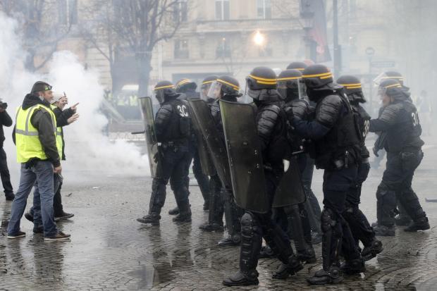 Protesters face riot police in Paris