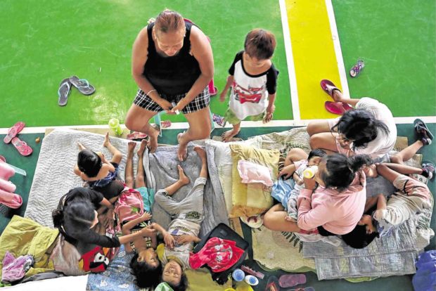SAFETY Families from a riverside community in Surigao City take shelter in a covered court at Barangay Washington to ensure their safety as Tropical Depression “Samuel” approaches provinces in the Visayas and Mindanao.  —ERWIN MASCARIÑAS
