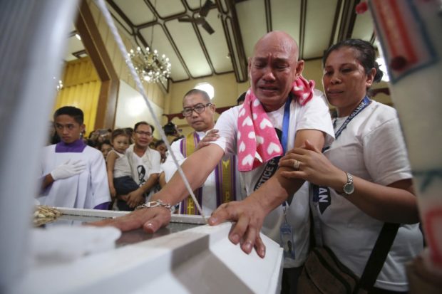 DRUG KILLING The parents of Kian delos Santos, who was killed in an alleged shootout with policemen on Aug. 16, 2017, as the Duterte administration waged a bloody crackdown on drug traffickers, grieve over the coffin of their 17-year-old son. —INQUIRER FILE PHOTOS