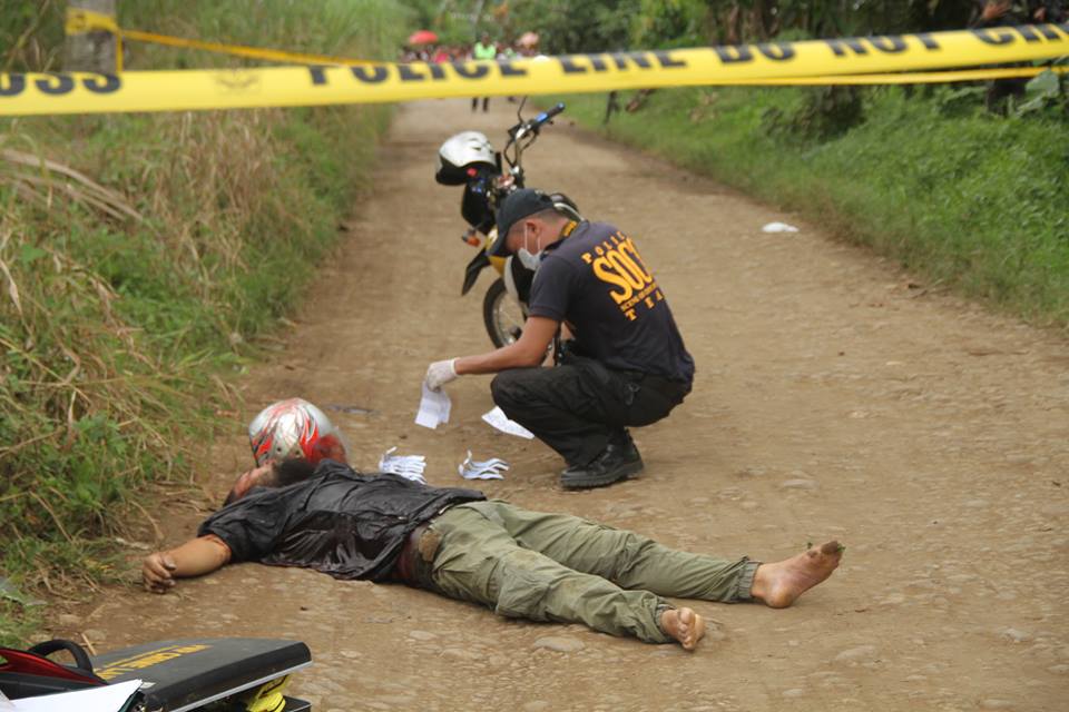 SOCO personnel processing the crime scene pulled to see one of the One thousand pesos bill used in the gun buy bust that led to the death of Muslim convert militant Joseph Anulga Jr., a.k.a Dawud in Ormoc City. / Robert Dejon, Inquirer Visayas