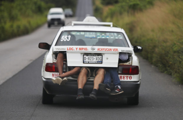 Central American migrants, part of the caravan hoping to reach the U.S. border, a ride on in the trunk of a taxi, in Acayucan, Veracruz state, Mexico, Saturday, Nov. 3, 2018. (AP Photo / Marco Ugarte)