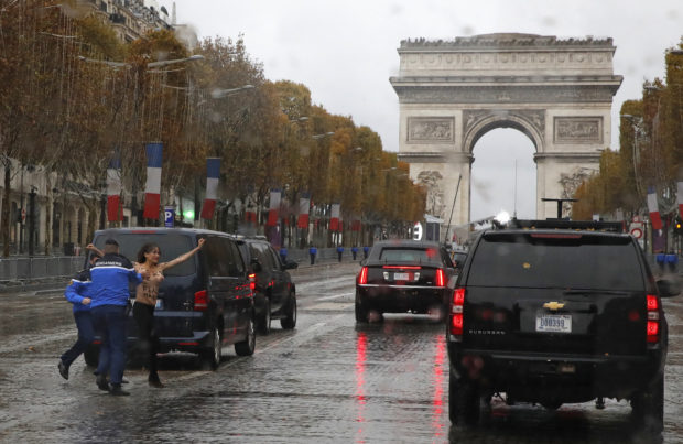 Donald Trump Topless Protest Paris WWI EDS NOTE NUDITY - French police officers apprehend a topless protestor who ran toward the motorcade of President Donald Trump who was headed on the Champs Elysees to an Armistice Day Centennial Commemoration at the Arc de Triomphe, Sunday Nov. 11, 2018, in Paris. Trump is joining other world leaders at centennial commemorations in Paris this weekend to mark the end of World War I. (AP Photo/Jacquelyn Martin)