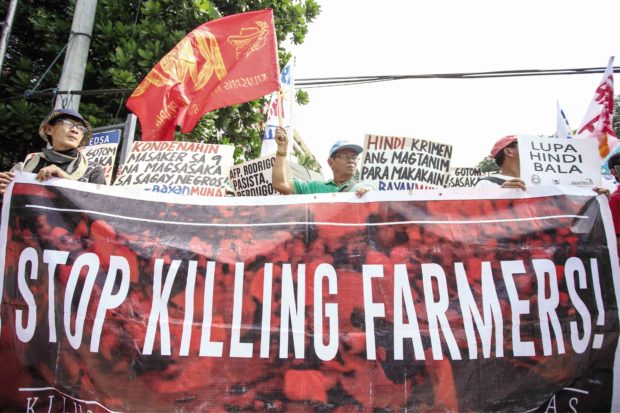 STREET OUTRAGE Groups of farmers rally in front of the military headquarters at Camp Aguinaldo, Quezon City, last month to condemn the massacre of nine farmers in Sagay City. —JAM STA. ROSA