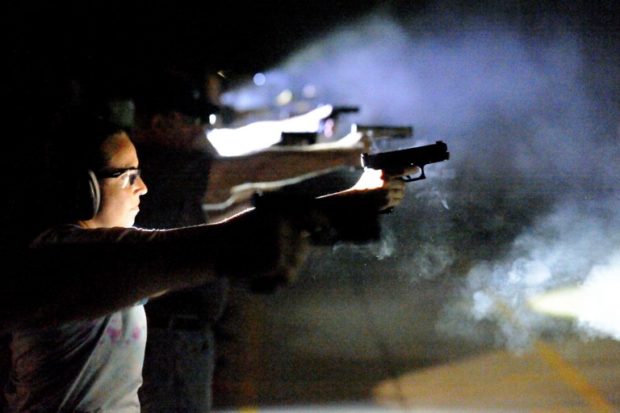 School teachers and administrators fire their guns during a nighttime drill while a three-day firearms course sponsored by FASTER Colorado at Flatrock Training Center in Commerce City, Colorado on June 27, 2018. - FASTER Colorado has been sponsoring firearms training to Colorado teachers and administrators since 2017. Over 100 Colorado teachers and administrators have participated in the course. Colorado is one of approximately 30 states that allow firearms within school limits, and an estimated 25 school districts in Colorado allow teachers and administrators to carry concealed firearms. (Photo by Jason Connolly / AFP)