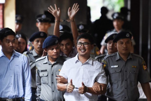 Reuters journalist Wa Lone (front) followed by Kyaw Soe Oo (C-back) arrive in court in Yangon on August 27, 2018 to face verdict after months of trial since they were detained on December 12, 2017. - A Myanmar court postponed ruling on August 27 whether two Reuters journalists, Myanmar nationals Wa Lone, 32, and Kyaw Soe Oo, 28 violated a state secrets law while reporting on the Rohingya crisis, a judge said, with a new date set for next week. (Photo by YE AUNG THU / AFP)
