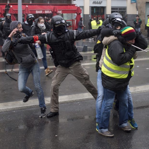 French plain clothes policemen block a protester wearing a yellow vest (gilet jaune) as they protest against rising costs of living they blame on high taxes in Nantes, on December 15, 2018. - The "Yellow Vests" (Gilets Jaunes) movement in France originally started as a protest about planned fuel hikes but has morphed into a mass protest against President's policies and top-down style of governing. (Photo by Sebastien SALOM-GOMIS / AFP) protests