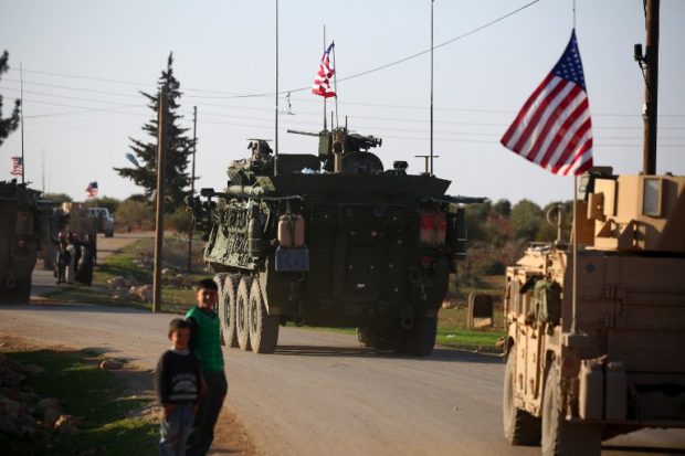 (FILES) In this file photo taken on March 05, 2017 A convoy of US forces armoured vehicles drives near the village of Yalanli, on the western outskirts of the northern Syrian city of Manbij. - The United States is preparing to withdraw its troops from Syria, US media reported on December 19, 2018, a major move that throws into question America's role in the region. (Photo by DELIL SOULEIMAN / AFP)