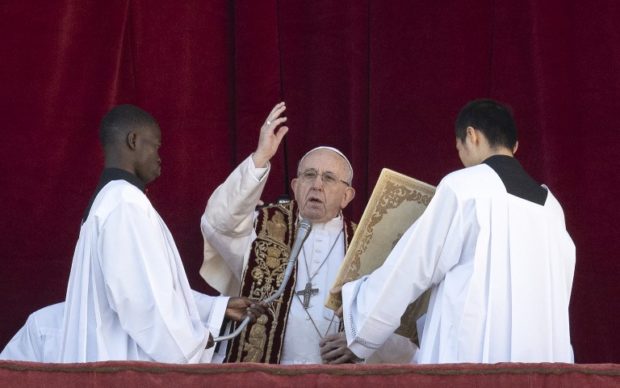 Pope Francis (C) blesses from the balcony of St Peter's basilica during the traditional "Urbi et Orbi" Christmas message to the city and the world, on December 25, 2018 at St Peter's square in the Vatican. (Photo by Tiziana FABI / AFP)