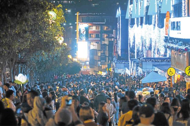 CROWDED Tourists, students and residents crowd Session Road in Baguio as the city lights its Christmas displays. —RICHARD BALONGLONG