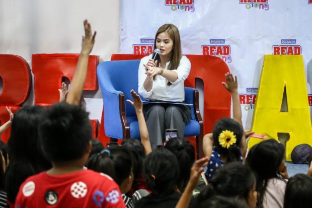 GUEST READER Television actress Bea Binene, one of the guest storytellers in the Inquirer Read- Along session on Saturday, reads to street children “Nang Magkakulay ang Nayon” (When the Village Became Colorful), a story of how people worked together to transform their dull and dusty village into a colorful and vibrant place. —JAM STA. ROSA