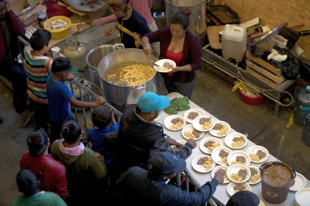 Hondruran migrants line up for breakfast in Mexico