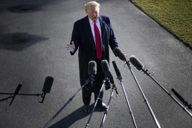 US President Donald Trump speaks to the press as he departs the White House in Washington, DC, on January 6, 2019, for meetings at Camp David. - President Donald Trump stood firm Sunday on his demand for billions of dollars to fund a border wall with Mexico, which has forced a shutdown of the US government now entering its third week."We have to build the wall," Trump told reporters as he left the  White House for the Camp David presidential retreat, while  conceding that the barrier could be "steel instead of concrete." (Photo by Jim WATSON / AFP)
