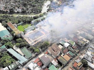 TOP SCHOOL Sacred Heart College, one of the top Catholic schools in Quezon province, has produced professionals and civic leaders since its founding as an institution for poor children in 1884. At right is a drone shot of the raging fire. —PHOTOS BY DELFIN T. MALLARI JR. AND TSIBOY MALLARI