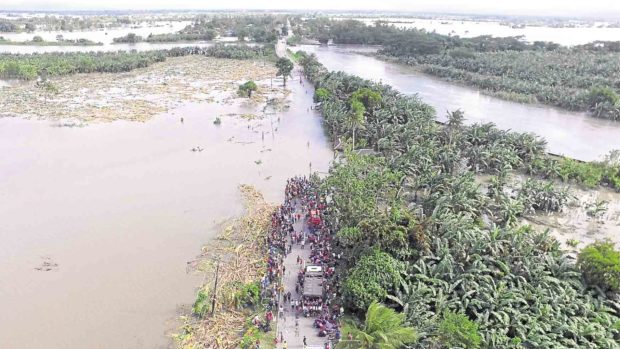 Motorists are stranded as floodwaters submerge a section of the Strong Republic Nautical Highway in Calapan City, Oriental Mindoro.  STORY: Mindoro onion farmers hit by low prices, floods