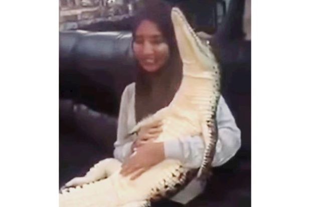 Malaysian woman comes under fire for hugging crocodile